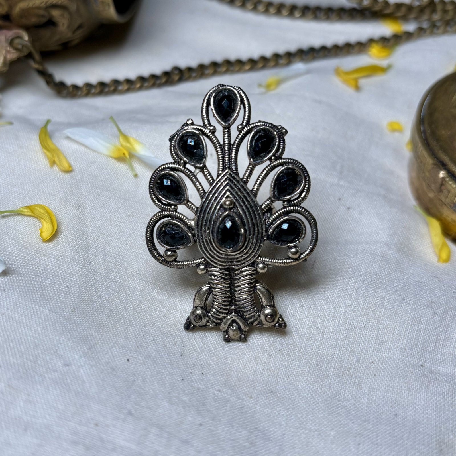 a peacock flare tail oxidised finish ring with black drop shaped stones by silly owl